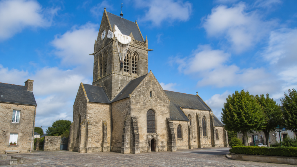 he church at Sainte-Mère-Église with the commemorative paratrooper display on its spire, opposite the Airborne Museum in Normandy.