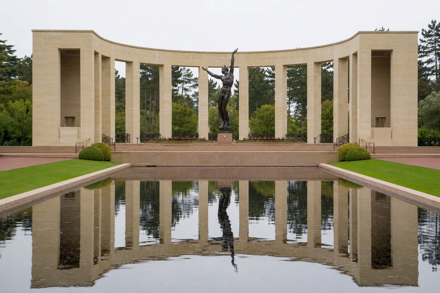 The memorial colonnade, bronze statue, and reflecting pool at the American Cemetery in Normandy