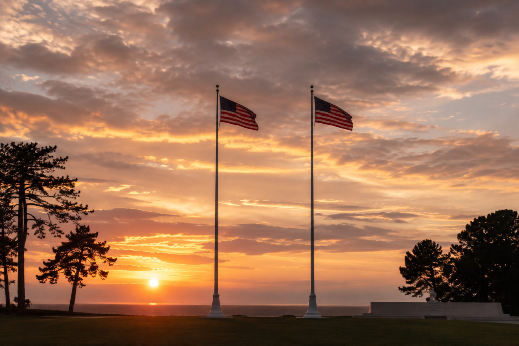 American flags flying at sunset over the Normandy American Cemetery at Colleville-sur-Mer